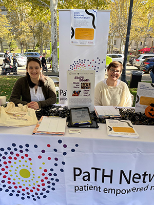 Two PaTH team members sit behind the PaTH Network's table at the Buddy Walk